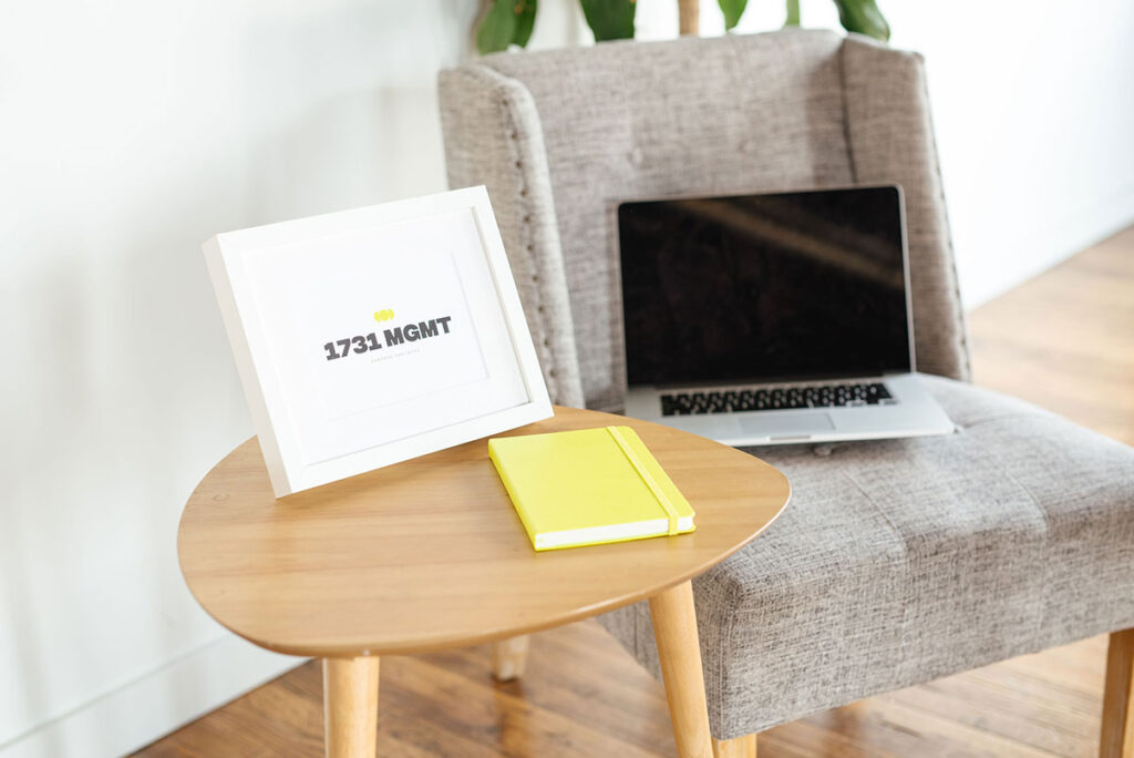 1731 MGMT logo in a white picture frame on a table top.